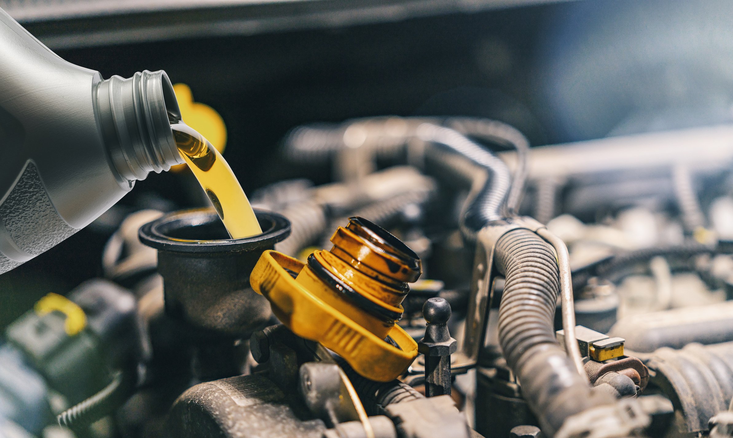 Pouring Oil to Car Engine. Fresh Oil Poured during an Oil Change